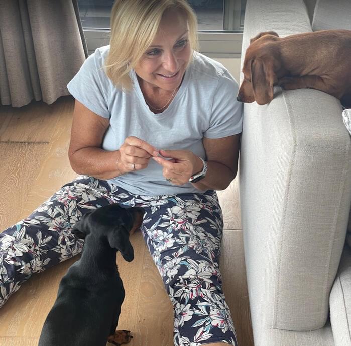 Monika Taus sitting on floor with two dogs.